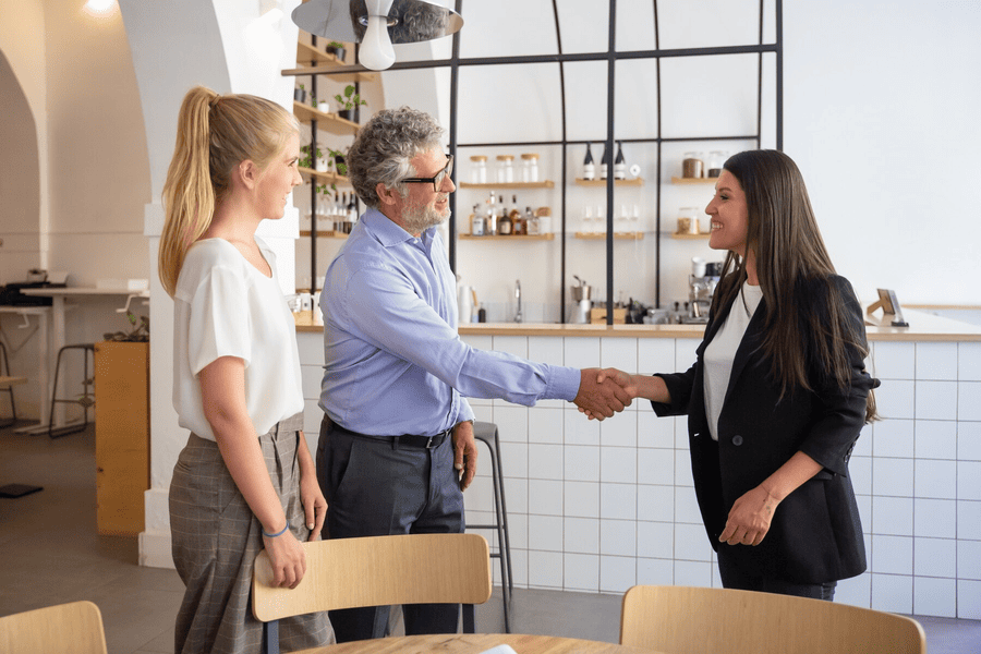 successful-female-business-representative-meeting-with-customers-shaking-hands